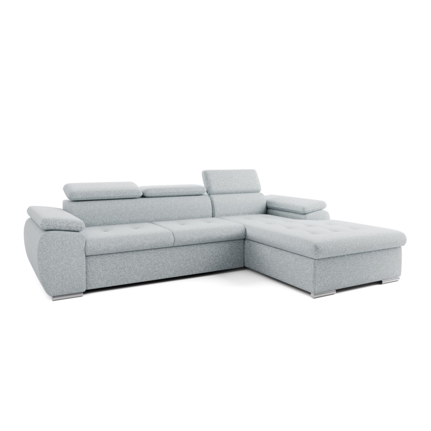 Rohová sedačka svetlošedej farby stojí v moderne zariadenej obývacej izbe. Sedačka je umiestnená na svetlej koberci pred nízkym konferenčným stolíkom. V pozadí je vidieť okno s výhľadom do prírody a časť steny s obrazom a nábytkom.