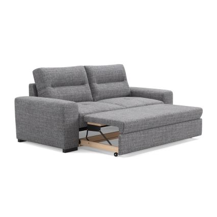 Rozkladacia sedačka s výsuvným lôžkom sa rozkladá. Sedačka je sivá, látková. Nachádza sa na bielom pozadí.