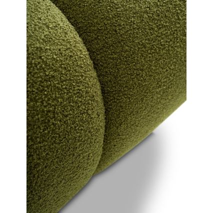 Čalúnený nábytok, tmavozelenej farby s mäkkou, plyšovou textúrou, je zobrazený detailne, pričom sú viditeľné prešitie a zaoblené tvary. Je umiestnený na svetlom pozadí.