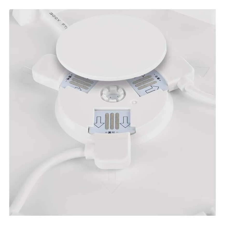 Biely kruhový panel sa otvára, odhaľujúc vnútorné LED diódy a konektory. Panel je pripojený k elektrickému káblu. Na panely sú šípky a text „+極和-極“.