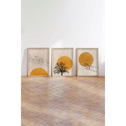 Tri obrazy s motívom vtákov a slnka sú umiestnené na stene. Stredný obraz zobrazuje strom pod žltým slnkom. Bočné obrazy zobrazujú kŕdle vtákov letiacich smerom k žltému slnku. Všetky sú zarámované a stoja na drevenej podlahe.