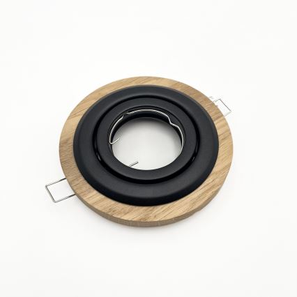 Svietidlový rám z dreva a kovu leží na bielom podklade. Rám je okrúhly, s hnedým dreveným vonkajším krúžkom a čiernym kovovým vnútorným krúžkom. Má dva kovové úchyty.