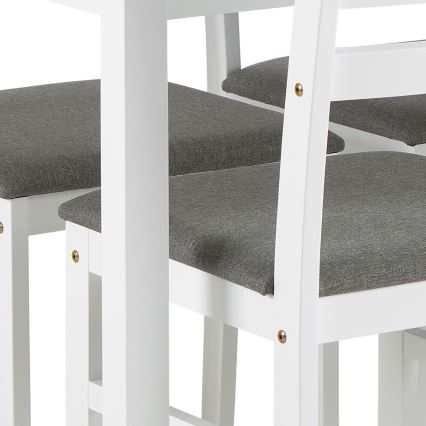 Biele stoličky s tmavosivými čalúnenými sedákmi sú umiestnené pri bielom stole. Stoličky majú jednoduchý dizajn a viditeľné skrutky.