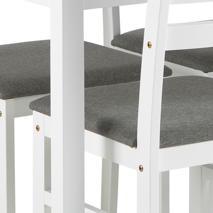 Biele stoličky s tmavosivými čalúnenými sedákmi sú umiestnené pri bielom stole. Stoličky majú jednoduchý dizajn a viditeľné skrutky.