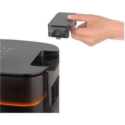 Ruka vyberá nádobku z vrchnej časti čierneho zariadenia s oranžovým podsvietením. Zariadenie má oválny tvar a otvor na vrchu.