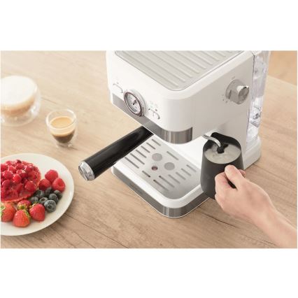 Espresso kávovar pripravuje mliečnu penu. Nachádza sa na drevenom stole, vedľa taniera s ovocím a už pripravenými šálkami kávy.