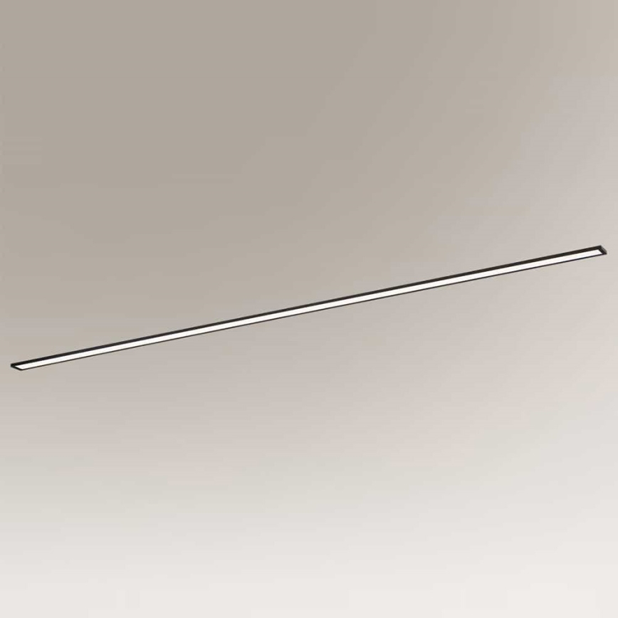 Dlhá tenká LED lampa je umiestnená vodorovne pred svetlohnedým pozadím. Lampa svieti.