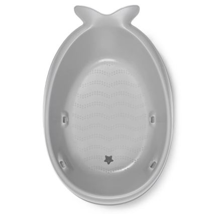 Šedá detská vanička v tvare ryby je pripravená na kúpanie. Vanička má zvlnený vzor a otvor v tvare hviezdy. Je umiestnená na bielom pozadí.