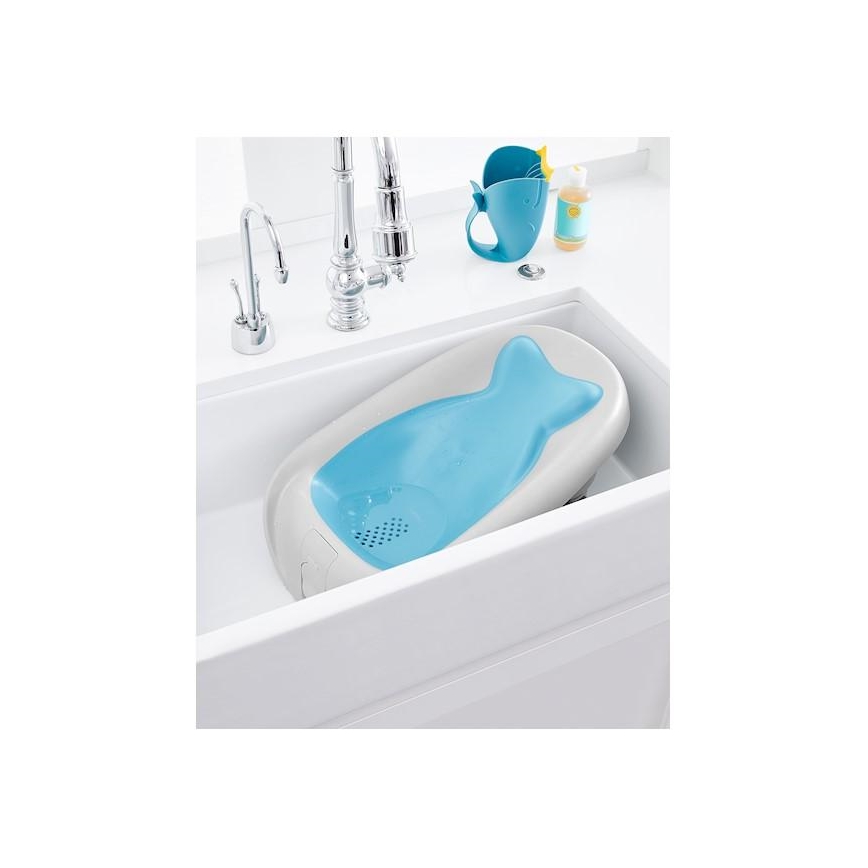 Detská vanička je umiestnená v dreze. Vanička je svetlo šedá s modrou vložkou. Na dreze sa nachádza odkvapkávacia nádoba a fľaštička.
