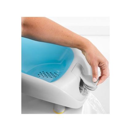 Ruka otvára odtok modrobielych detských vaničiek, z ktorých vyteká voda. Vanička je umiestnená v kúpeľni.