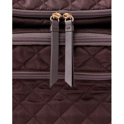 Dvojica zipsov s koženými šnúrkami sa nachádza na tmavohnedej prešívanej textílii s viacerými vreckami na zips.