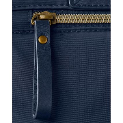 Kožený remienok zapínajúci zips na tmavomodrej textílii s jemnou diagonálnou štruktúrou. Zips je zlatý. Remienok je pripevnený k kovovému jazýčku.