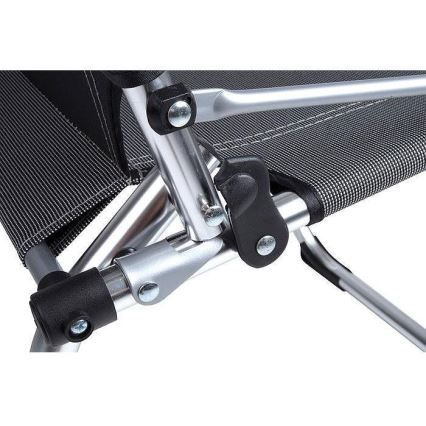 Skladacia stolička s nastaviteľnou opierkou je zložená z hliníkových rúrok a tmavošedého textilného poťahu. Mechanizmus nastavovania je viditeľný detailom čiernych plastových spojok.