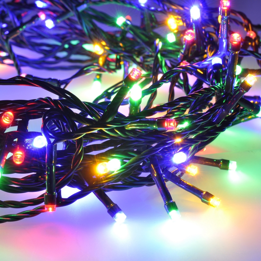 Elektrický svetelný veniec s viacfarebnými LED diódami je zvinutý na svetlej ploche. Diody vyžarujú červenú, zelenú, žltú a modrú farbu. Káble sú čierne.