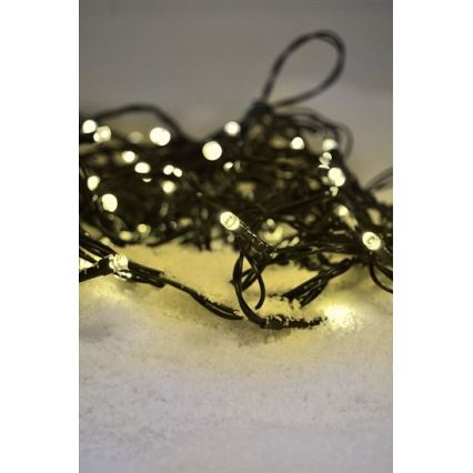 Svetielka s teplým bielym svetlom ležia na umelom snehu. Svietiace diódy sú umiestnené na tenkom čiernom kábli, ktorý je zamotaný.