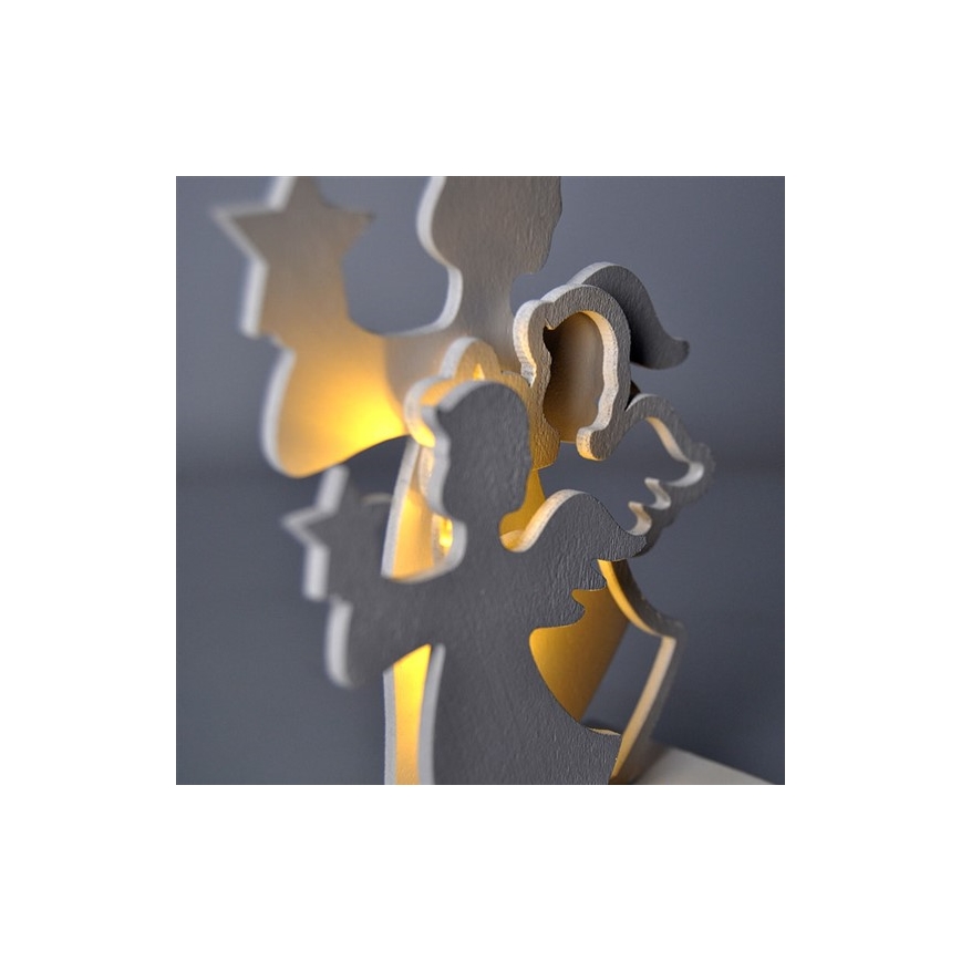 Drevená dekorácia s motívom anjelov a hviezd svieti vnútorným svetlom. Anjeli sú prekrytí a vyrezaní do tvaru. Stojí na podstavci.