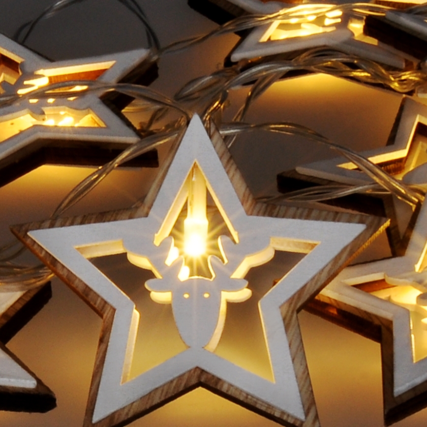 Svetlá vo forme hviezd s vyrezávaným jeleňom svietia. Hviezdy sú drevené, biele s hnedým okrajom. Svetlá sú prepojené tenkým káblom.