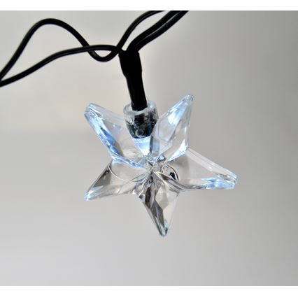 Hviezdická LED dióda visí na čiernom kábli. Svietiaci element je umiestnený v priehľadnej hviezdicovitej ozdobe. Pozadím je svetlosivá plocha.