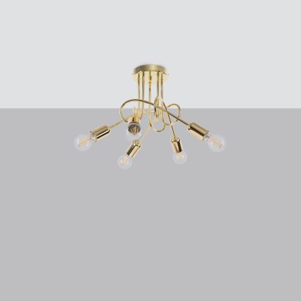 Zlatá stropná lampa s piatimi žiarovkami visí z plochého stropu. Žiarovky sú pripevnené na ozdobných, zakrivených ramenách. Lampa je umiestnená na neutrálnom sivom pozadí.
