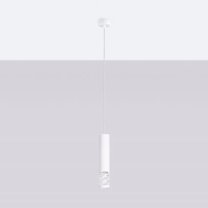Biela závesná lampa s valcovitým tienidlom, ktoré má v strede perforáciu, visí zo stropu pred svetlosivou stenou.