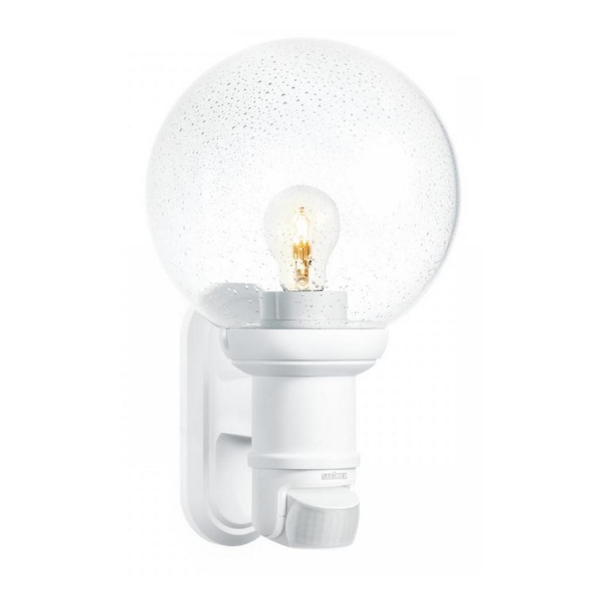 Biela guľatá nástenná lampa s priesvitným skleneným tienidlom obsahuje viditeľnú žiarovku. Nápis „STEINEL“ je na držiaku lampy. Lampa je určená na montáž na stenu.