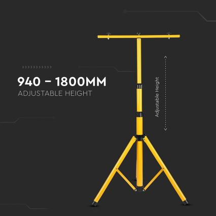 Žltý stojan s trojnožkou a priečnou tyčou na vrchu, nastaviteľná výška 940 – 1800 mm, stojí na tmavom pozadí.