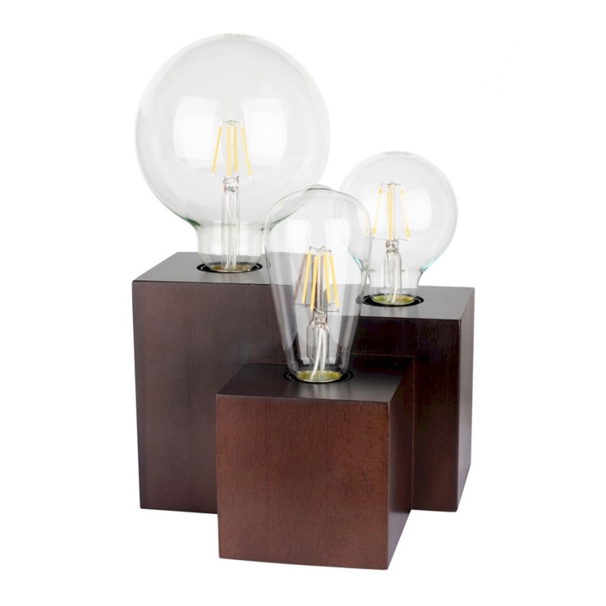 Tri LED žiarovky sú umiestnené na drevených kockách. Najväčšia žiarovka je v hornej časti, menšie sú pod ňou. Celok tvorí stolnú lampu.