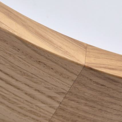 Drevená miska s okrúhlym tvarom je zobrazená zblízka. Viditeľná je jej konštrukcia, zložená z dvoch častí spojených stredovým spojom. Svetlo hnedé drevo má výraznú textúru.