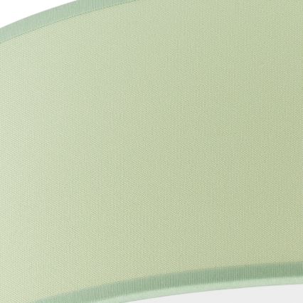 Svetlozelený textilný tienidlo s jemnou textúrou je zobrazené zblízka. Tienidlo je obdĺžnikové s mierne zaoblenými rohmi a má svetlozelený lemovací pás po obvode.