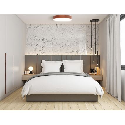 Dvojposteľ je prestrelená v spálni. Nad posteľou je stena s mramorovým vzorom a šedým čelom. V miestnosti sú stropné a visiace svietidlá.