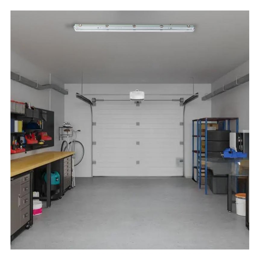 LED svietidlo svieti v garáži. Garáž obsahuje pracovný stôl, bicykel, regály s náradím a pneumatikami, a garážové dvere.