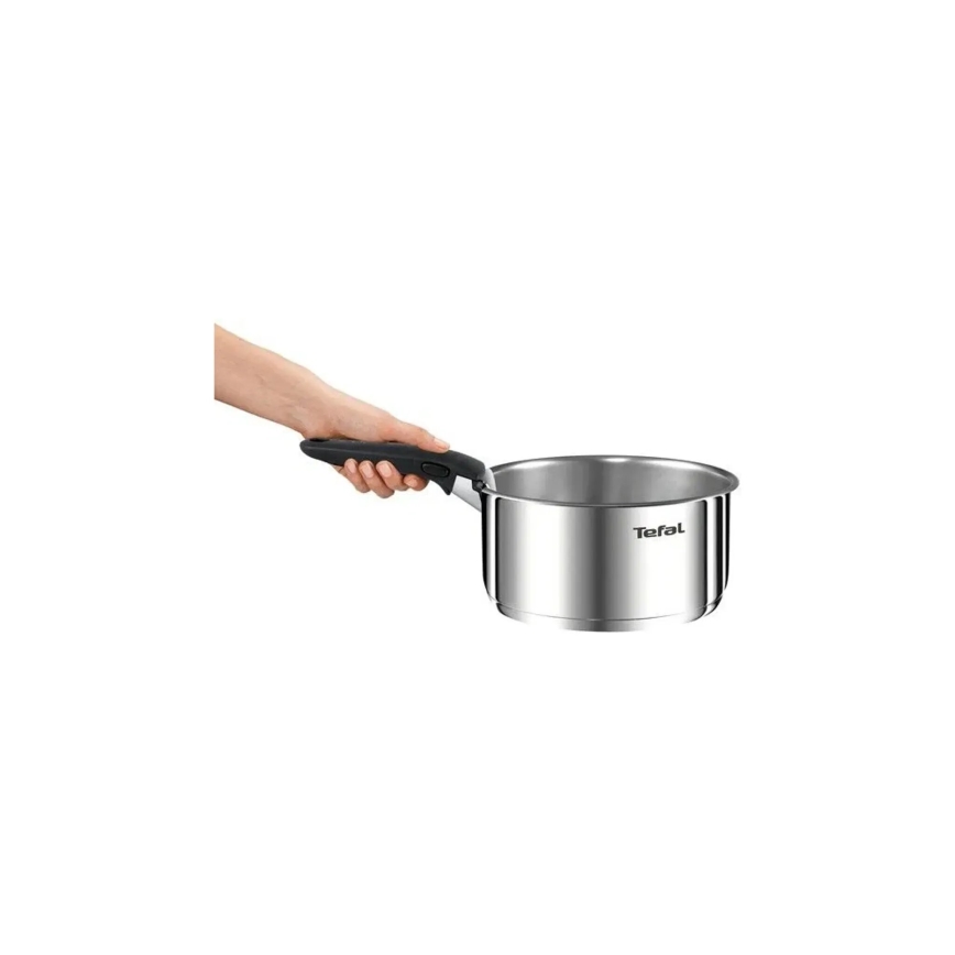 Nerezový hrniec Tefal drží ruka. Hrniec je stredne veľký, s čiernou rukoväťou. Pozadie je biele.