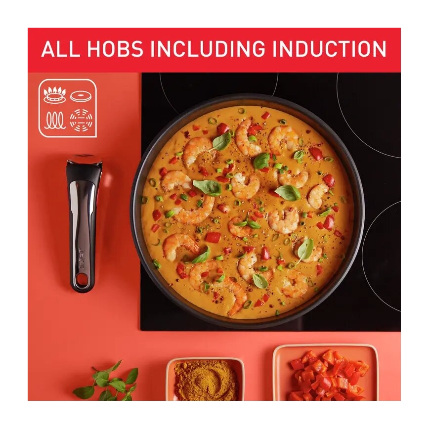 Panvica s krevetovým jedlom sa varí na indukčnej doske. Okrem panvice sú viditeľné korenie a nakrájaná paprika. Text na obrázku uvádza: „ALL HOBS INCLUDING INDUCTION“.