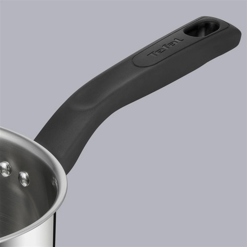 Nerezový hrniec s čiernou rukoväťou Tefal má ergonomický tvar. Rukoväť je pripevnená k kovovému telu hrnca. Povrch je hladký.