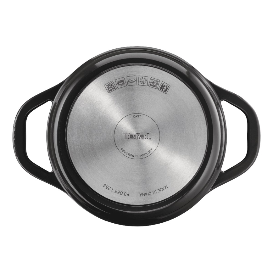 Čierna liatinová nádoba Tefal s dvoma úchytkami, zobrazená zhora. Dno nádoby je z nehrdzavejúcej ocele s označením „CAST“, „Tefal“, „INDUCTION TECHNOLOGY“, „MADE IN CHINA“, „P9 085 1253“ a symbolmi vhodnosti pre rôzne typy sporákov.