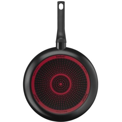 Panvica Tefal s čiernym povrchom a červeným dnom s bodkovaným vzorom je zobrazená zhora. Na dne je nápis Tefal a Made in France.