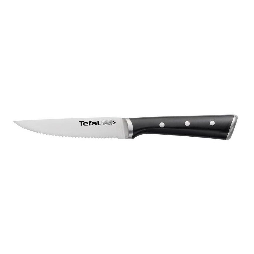 Nôž Tefal s pílkovým ostrim a čiernou rukoväťou s bielymi bodkami leží na bielom pozadí.