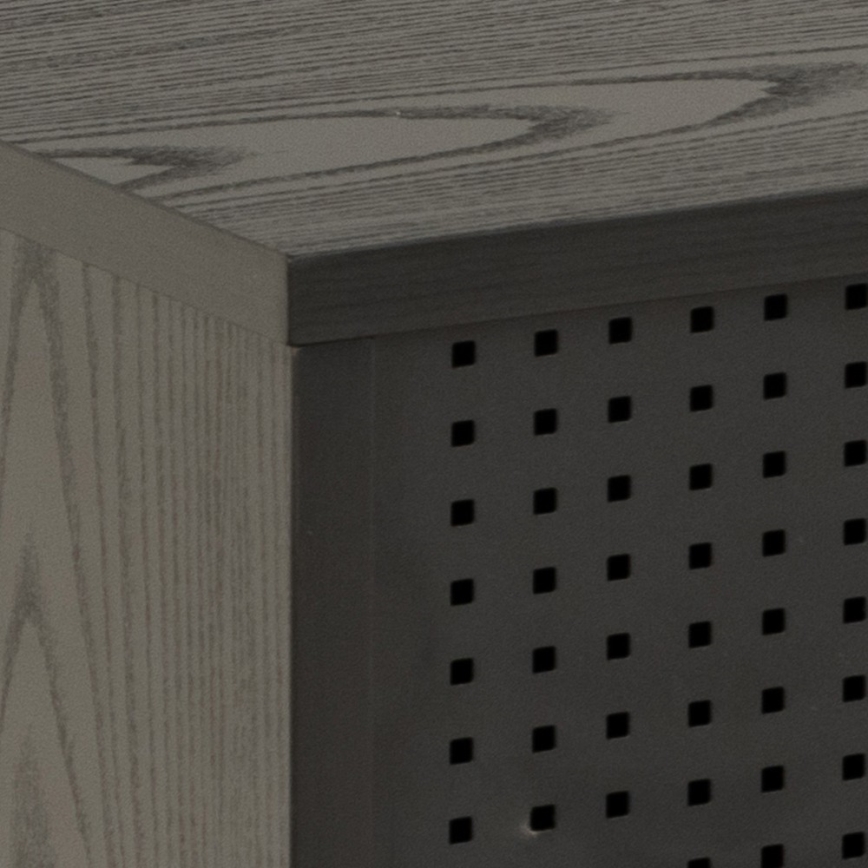 Štvorcová skrinka s drevom podobnou povrchovou úpravou má na jednej strane perforovaný panel. Horná časť je rovná, tmavosivá. Viditeľná je iba časť skrinky.