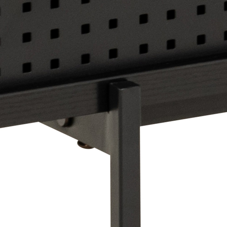 Čierna kovová polica s perforovanou prednou stranou je pripevnená k čiernym kovovým nohám skrutkami. Konštrukcia je jednoduchá a minimalistická.
