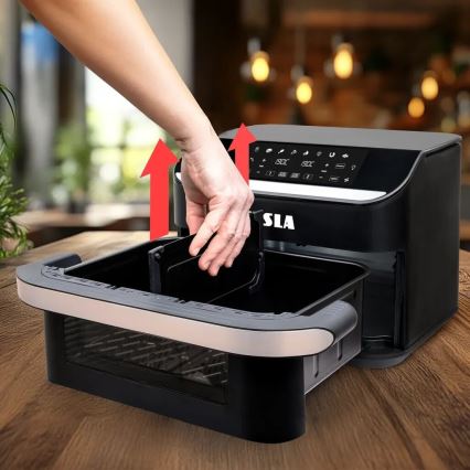 Ruka vkladá vnútornú nádobu do fritézy SLA. Fritéza je umiestnená na drevenom stole v rozmazanej kuchynskej kulisu.