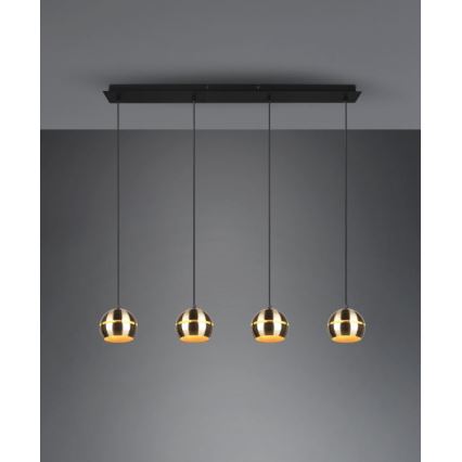 Trojramenné závesné svietidlo s kovovými guľovitými tienidlami zlato-bronzového odtieňa visí zo stropnej lišty. Tienidlá sú pripevnené k čiernym káblom. Svietidlo je umiestnené v neutrálnom prostredí.