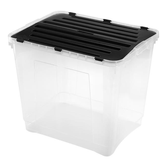 Priehľadná plastová škatuľa s čiernym vrchnákom s priečnymi drážkami stojí na bielom pozadí. Škatuľa je prázdna.