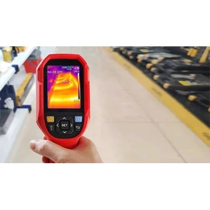 Termokamera meria teplotu v miestnosti. Na displeji zobrazuje teplotné rozloženie v stupňoch Celzia (max. 28,0 °C). Kamera je držaná v ruke pred policami s tovarom.