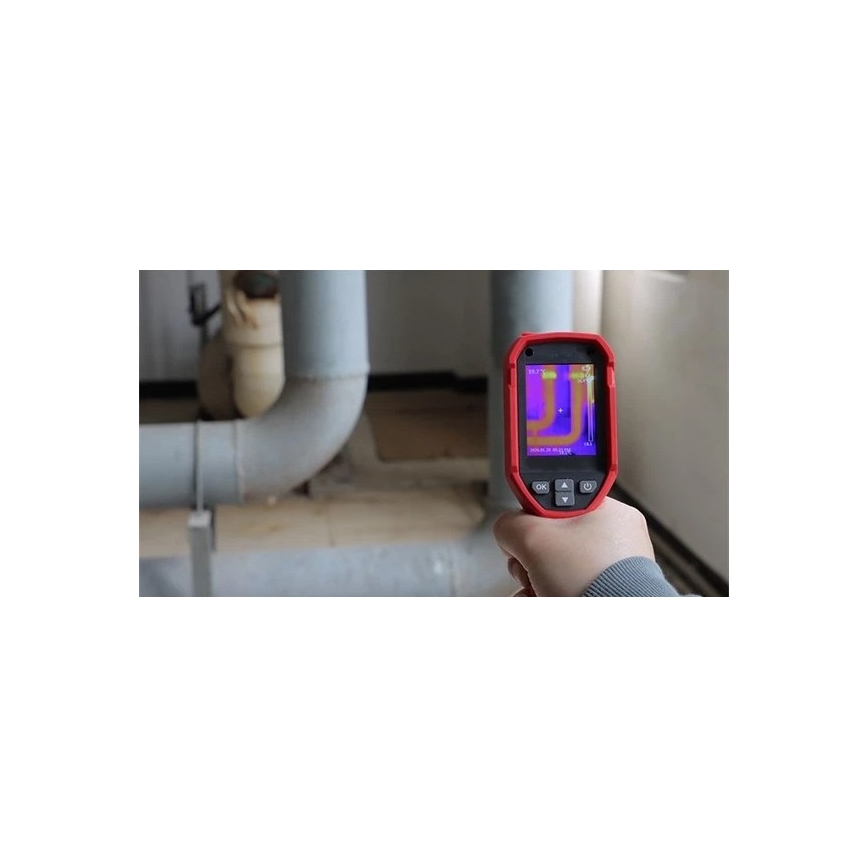 Termokamera meria teplotu potrubia. Displej zobrazuje teplotné rozdiely v infračervenom spektre. Prostredie je technická miestnosť s potrubím.