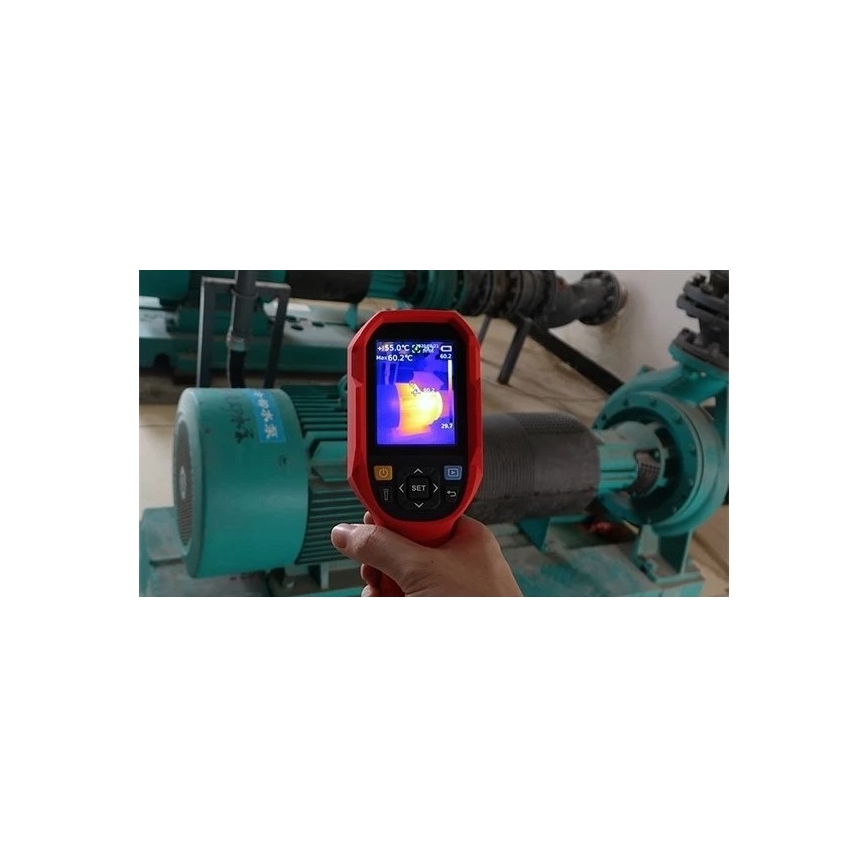Termokamera meria teplotu priemyselného zariadenia. Na displeji zobrazuje teplotu 60,2°C. Zariadenie je umiestnené v technickej miestnosti s priemyselnými motormi a potrubiami.