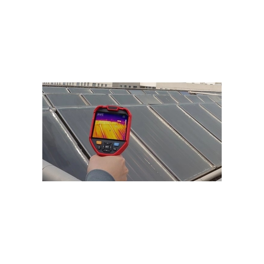 Termokamera sníma teplotu solárnych panelov na streche budovy. Displej termokamery zobrazuje infračervený záber s teplotou 24,6°C. Viditeľné sú rady solárnych panelov na plochej streche.