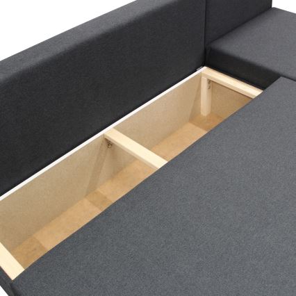 Rohová sedačka odhaľuje úložný priestor. Je rozdelený drevenou priečkou na dve časti. Úložný priestor je vystlaný hnedým materiálom a je umiestnený pod sivým čalúnením sedačky.