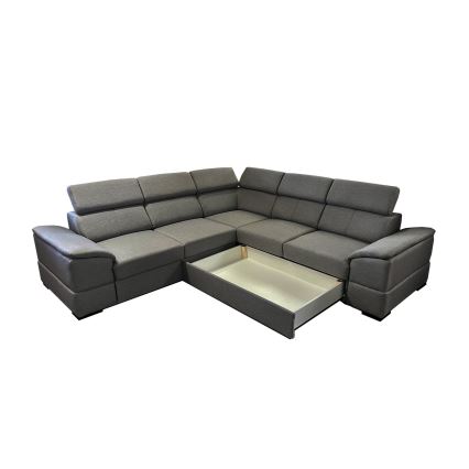 Rohová sedačka s tmavosivým čalúnením má vysunutý úložný priestor. Sedačka je delená na niekoľko častí, s opierkami a podsedákmi. Nachádza sa na bielom pozadí.