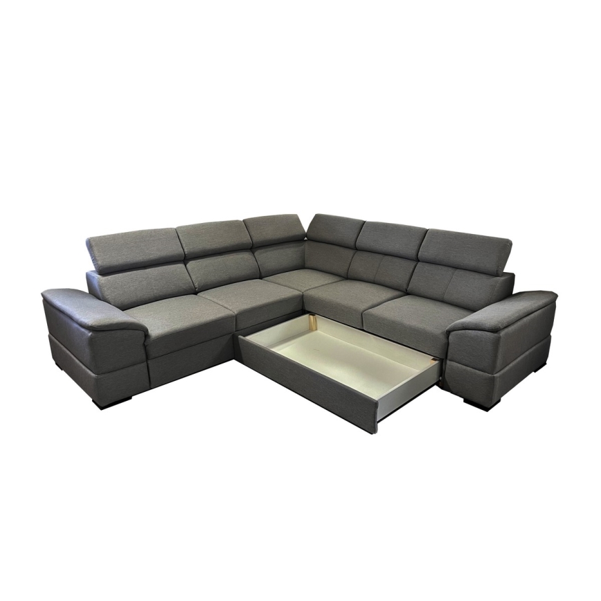 Rohová sedačka s tmavosivým čalúnením má vysunutý úložný priestor. Sedačka je delená na niekoľko častí, s opierkami a podsedákmi. Nachádza sa na bielom pozadí.
