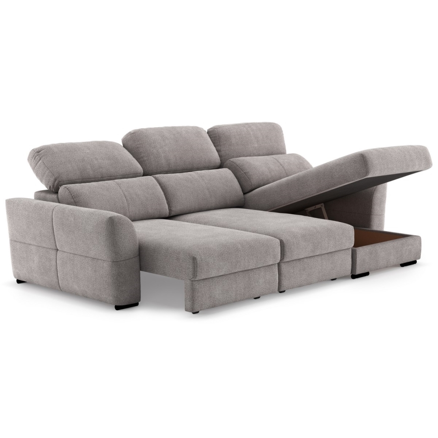 Rohová sedačka s otvoreným úložným priestorom v ľavej časti. Sedačka je svetlosivá, látková, s viacerými vankúšmi. Nachádza sa na bielom pozadí.